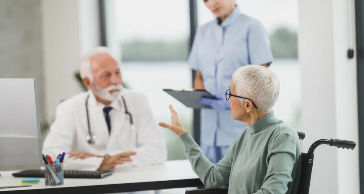 Médica conversando com paciente em consultório, com prontuário sobre a mesa