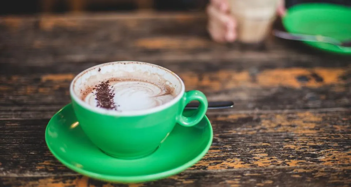 Xícara de café, folhas de chá verde e pimentas vermelhas sobre uma mesa clara